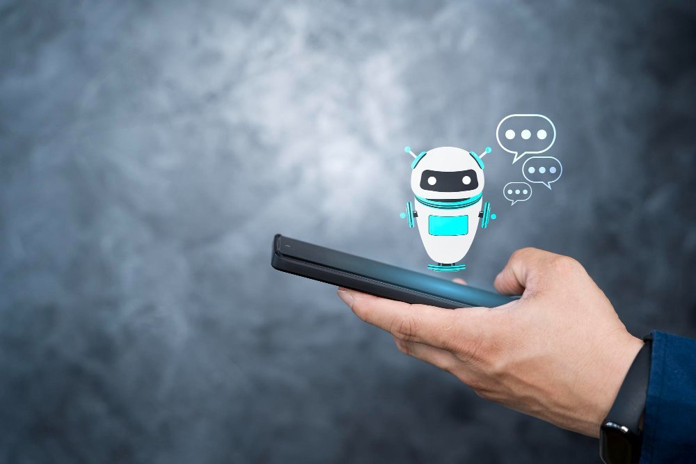 Chatbots: Uma mão segurando um smartphone com um personagem de chatbot ou assistente virtual na tela, com balões de fala indicando uma conversa.