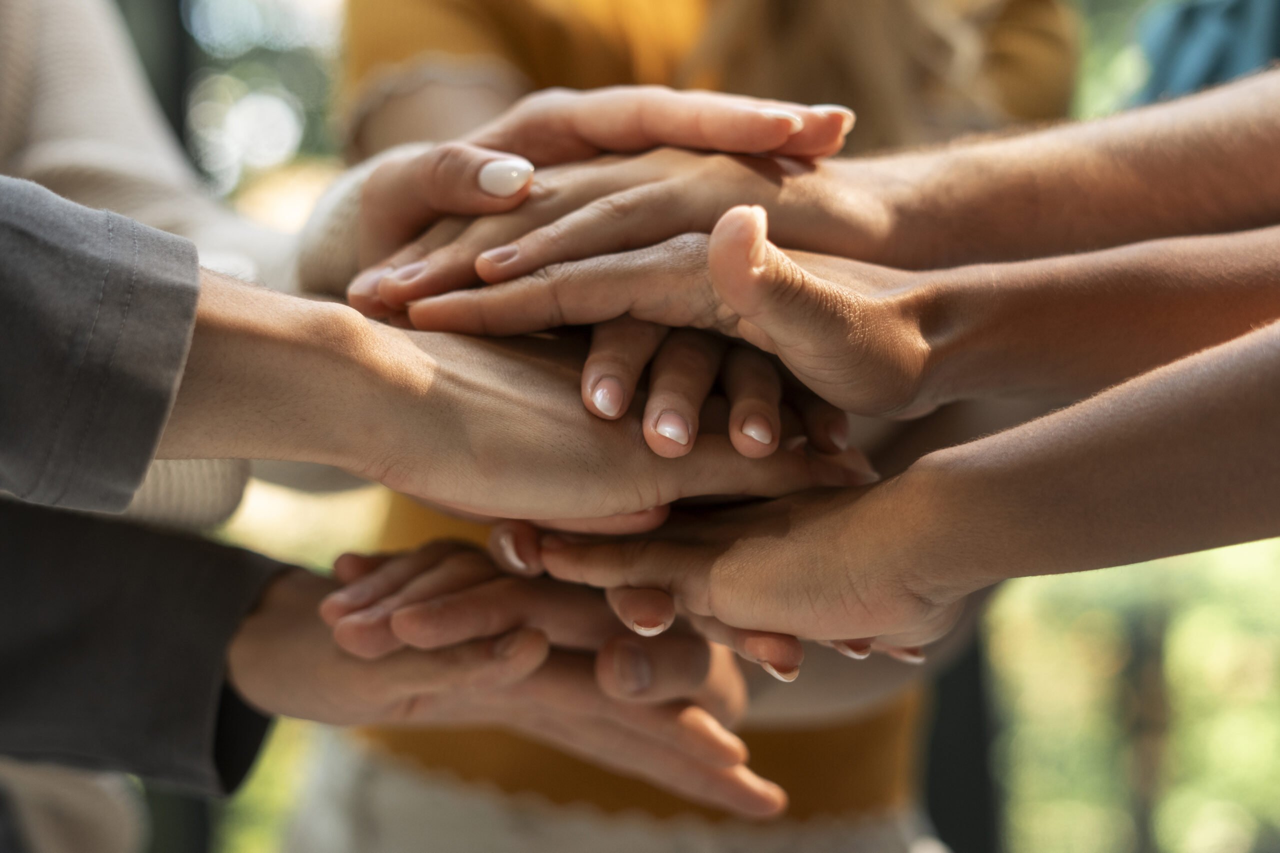 Logística Reversa e Responsabilidade Social: Um grupo de mãos diversas se unindo em um gesto de unidade e trabalho em equipe.